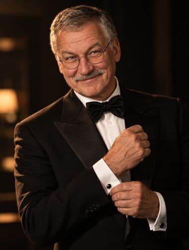 Werner in a tuxedo, medium shot in spy-movie lighting